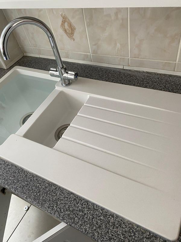 Ceramic kitchen sink and chrome mixer tap installation by Magico Plumbing And Heating in Chigwell